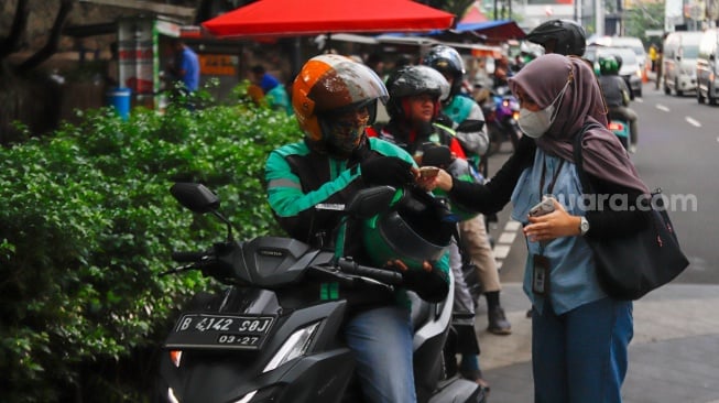 Pengemudi ojek daring usai mengantar penumpang di Stasiun Sudirman, Jakarta, Senin (20/5/2025). [Suara.com/Alfian Winanto]