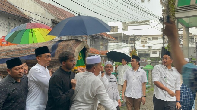 Anak Najwa Shihab, Izzat Ibrahim Assegaf (baju hitam) saat menandu keranda jenazah sang ayah, Ibrahim Sjarief Assegaf di TPU Jeruk Purut, Jakarta, Rabu, 21 Mei 2025. [dok: Narasi]