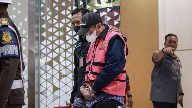 Mantan Dirut Bank DKI Zainudin Mapa (tengah) dikawal petugas menuju mobil tahanan usai menjalani pemeriksaan di Gedung Bundar Jampidsus Kejaksaan Agung (Kejagung), Jakarta, Rabu (21/5/2025). [ANTARA FOTO/Dhemas Reviyanto/foc]