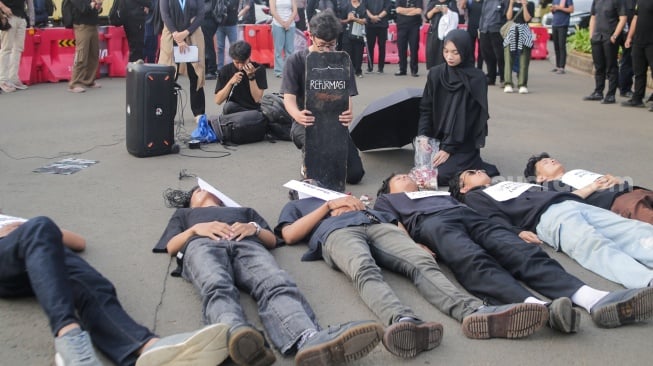 Para aktivis dari Jaringan Solidaritas Korban untuk Keadilan menggelar aksi teaterikal saat mengikuti Aksi Kamisan ke-862 di depan Istana Merdeka, Jakarta, Kamis (15/5/2025). [Suara.com/Alfian Winanto]
