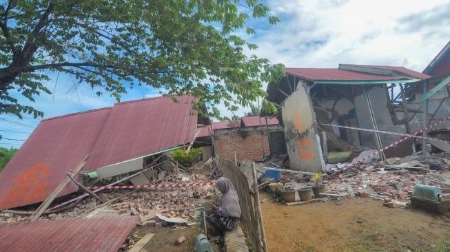 Warga duduk di dekat bangunan roboh pascagempa bumi berkekuatan magnitudo 6,3 di Kota Bengkulu, Bengkulu, Jumat (23/5/2025). [ANTARA FOTO/Muhammad Izfaldi/Lmo/rwa]