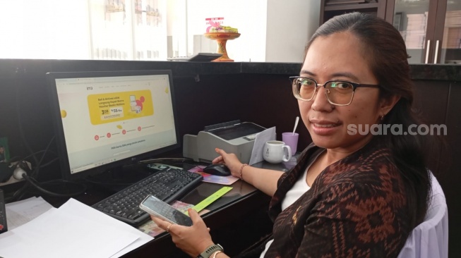 Admin Koperasi Radha Krishna Denpasar Ni Made Reza Anggraini yang juga pengguna IM3 Platinum saat ditemui di kantornya, Kamis (15/5/2025). [Suara.com/ Eviera Paramita Sandi] 