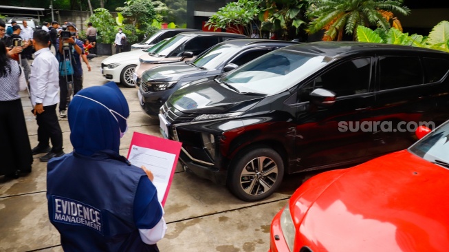 Petugas memeriksa kendaraan yang menjadi barang sitaan di Gedung Merah Putih Komisi Pemberantasan Korupsi (KPK), Jakarta, Senin (26/5/2025). [Suara.com/Alfian Winanto] 