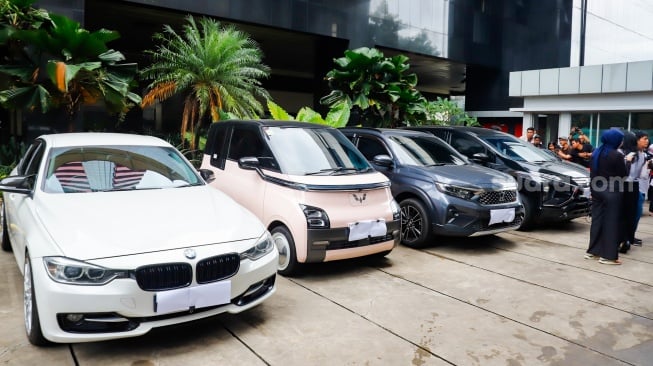 Petugas memeriksa kendaraan yang menjadi barang sitaan di Gedung Merah Putih Komisi Pemberantasan Korupsi (KPK), Jakarta, Senin (26/5/2025). [Suara.com/Alfian Winanto] 