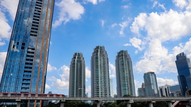 Pemandangan langit biru menghiasi Kota Jakarta pada Selasa (27/5/2025). [Suara.com/Alfian Winanto]