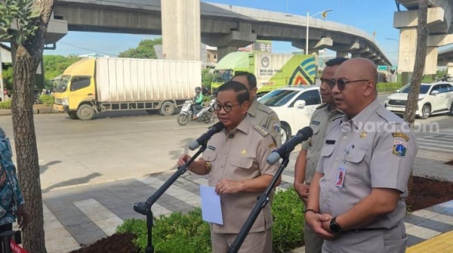 Gubernur DKI Jakarta Pramono Anung (kiri) usai mengikuti kegiatan penanaman pohon di kolong Tol Cakung, Jakarta Timur pada Selasa (27/5/2025). (Suara.com/Fakhri Fuadi)
