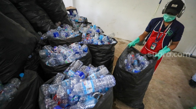 Pekerja memilah sampah botol plastik untuk diolah di Waste Treatment Plant Gelora Bung Karno, Jakarta, Selasa (27/5/2025). [Suara.com/Alfian Winanto]