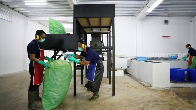 Pekerja mengolah sampah botol plastik di Waste Treatment Plant Gelora Bung Karno, Jakarta, Selasa (27/5/2025). [Suara.com/Alfian Winanto]
