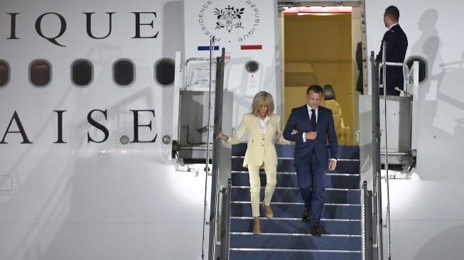 Presiden Prancis Emmanuel Macron (kanan) bersama istri Brigitte Macron (kiri) menuruni tangga pesawat saat tiba di Pangkalan Udara TNI AU Halim Perdanakusuma, Jakarta, Selasa (27/5/2025). [ANTARA FOTO/Hafidz Mubarak A/sgd/foc]