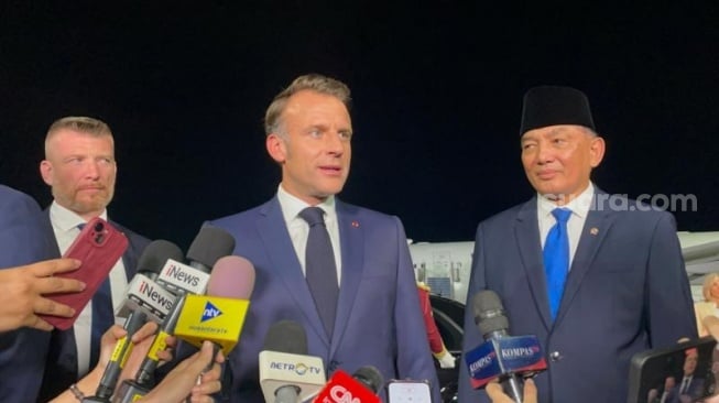 Presiden Prancis Emmanuel Macron (tengah) saat tiba di Indonesia. (Suara.com/Novian Ardiansyah)