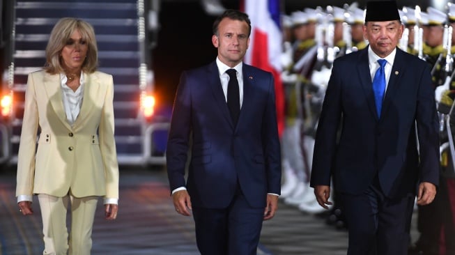 Presiden Prancis Emmanuel Macron (tengah) bersama istri Brigitte Macron (kiri) didampingi Menteri Pertahanan Sjafrie Sjamsoeddin berjalan menuju kendaraannya saat tiba di Pangkalan Udara TNI AU Halim Perdanakusuma, Jakarta, Selasa (27/5/2025). [ANTARA FOTO/Hafidz Mubarak A/sgd/foc]
