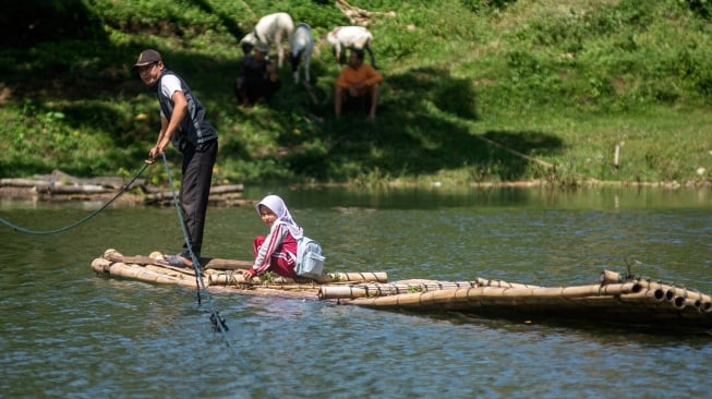Siswa SDN Panaruban menyeberangi sungai Cicadas menggunakan rakit di Desa Karanganyar, Cililin, Kabupaten Bandung Barat, Jawa Barat, Selasa (27/5/2025). [ANTARA FOTO/Abdan Syakura/Spt]
