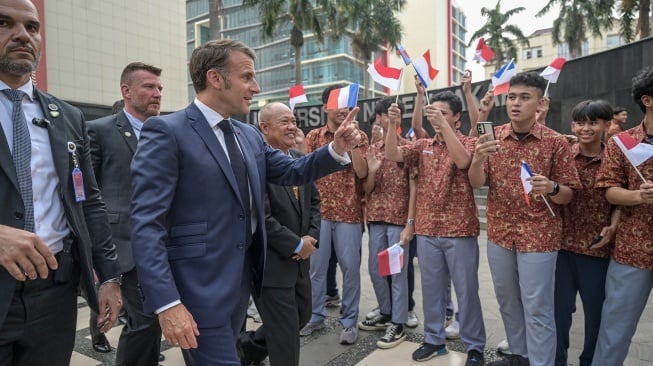 Presiden Prancis Emmanuel Macron (ketiga kiri) menyapa pelajar setibanya di Universitas Negeri Jakarta (UNJ), Jakarta, Rabu (28/5/2025). [ANTARA FOTO/Fauzan/rwa]
