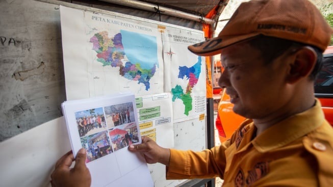 Petugas BPBD memasang data informasi di posko pencarian korban longsor di lokasi galian C, Cipanas, Dukuhpuntang, Kab. Cirebon, Jawa Barat, Sabtu (31/5/2025). [ANTARA FOTO/Dedhez Anggara/agr]