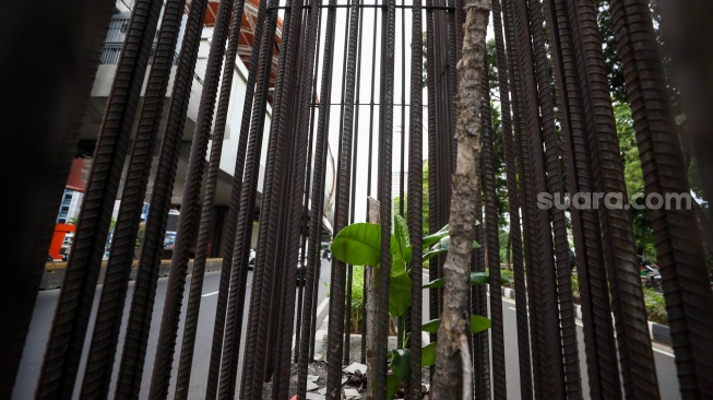 Pengendara melintas di dekat tiang bekas proyek monorel Jakarta di kawasan Jalan HR Rasuna Said, Jakarta, Senin (2/6/2025). [Suara.com/Alfian Winanto]