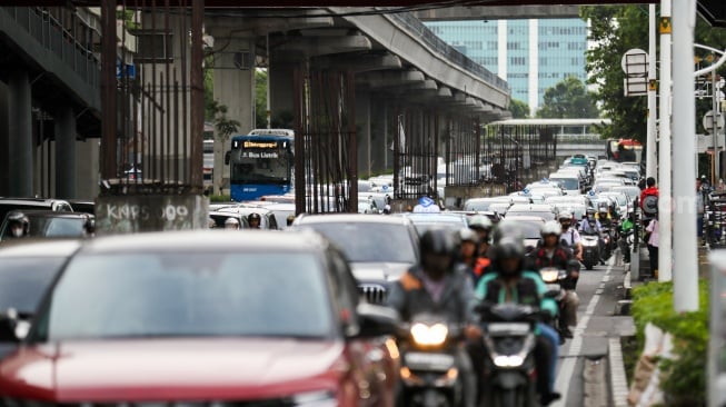 Pengendara melintas di dekat tiang bekas proyek monorel Jakarta di kawasan Jalan HR Rasuna Said, Jakarta, Senin (2/6/2025). [Suara.com/Alfian Winanto]