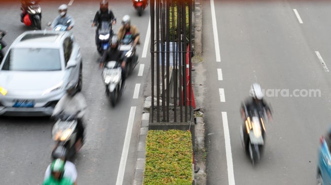 Pengendara melintas di dekat tiang bekas proyek monorel Jakarta di kawasan Jalan HR Rasuna Said, Jakarta, Senin (2/6/2025). [Suara.com/Alfian Winanto]