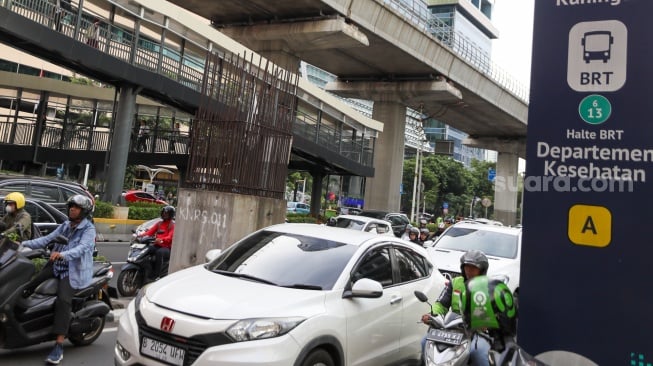Pengendara melintas di dekat tiang bekas proyek monorel Jakarta di kawasan Jalan HR Rasuna Said, Jakarta, Senin (2/6/2025). [Suara.com/Alfian Winanto]