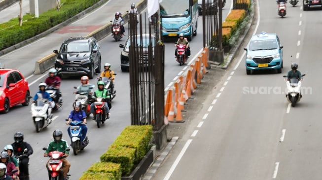 Pengendara melintas di dekat tiang bekas proyek monorel Jakarta di kawasan Jalan HR Rasuna Said, Jakarta, Senin (2/6/2025). [Suara.com/Alfian Winanto]