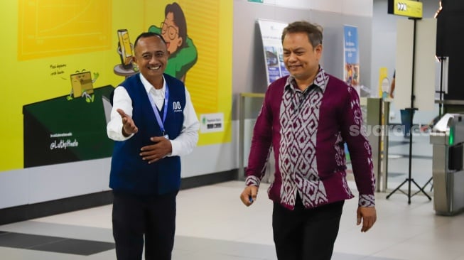Pekerja lanjut usia (lansia) menyapa pengguna MRT Jakarta di Stasiun Bundaran HI, Jakarta, Selasa (3/6/2025). [Suara.com/Alfian Winanto]