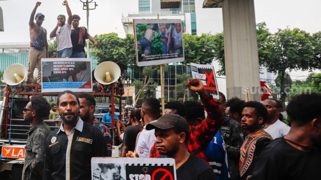 Massa dari Ikatan Pelajar dan Mahasiswa Moni (IPMMO) saat menggelar aksi unjuk rasa di depan Gedung Kementerian HAM, Jakarta, Selasa (3/6/2025). [Suara.com/Alfian Winanto]