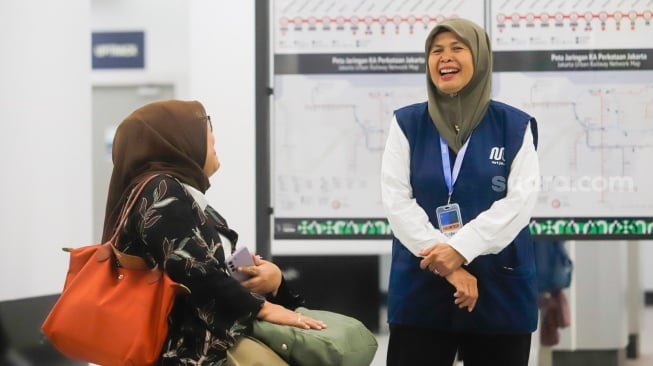 Pekerja lanjut usia (lansia) menyapa pengguna MRT Jakarta di Stasiun Bundaran HI, Jakarta, Selasa (3/6/2025). [Suara.com/Alfian Winanto]