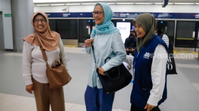 Pekerja lanjut usia (lansia) menyapa pengguna MRT Jakarta di Stasiun Bundaran HI, Jakarta, Selasa (3/6/2025). [Suara.com/Alfian Winanto]