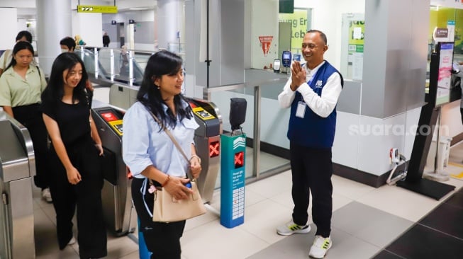 Pekerja lanjut usia (lansia) menyapa pengguna MRT Jakarta di Stasiun Bundaran HI, Jakarta, Selasa (3/6/2025). [Suara.com/Alfian Winanto]