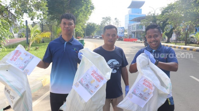 Kegiatan DLH saat melakukan aksi pungut sampah di GOR Kadrie Oening pada Kamis, 5 Juni 2025. [SuaraKaltim.id/Giovanni]