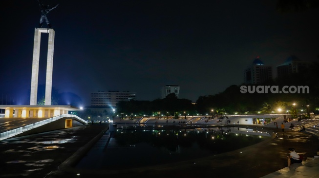 Warga beraktivitas saat malam hari di Taman Lapangan Banteng, Jakarta, Senin (9/6/2025). [Suara.com/Alfian Winanto]