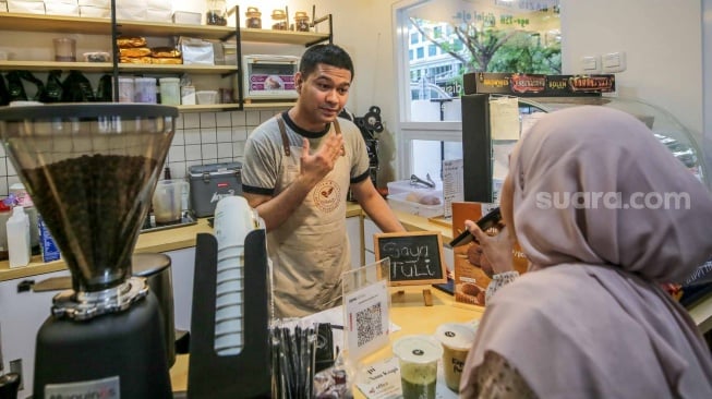 Pekerja yang juga penyandang disabilitas melayani pelanggan di Kopi Difabis, Terowongan Kendal, Jakarta, (9/6/2025). [Suara.com/Alfian Winanto]