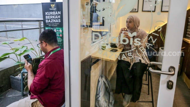 Pelanggan meminun kopi di Kopi Difabis, Terowongan Kendal, Jakarta, (9/6/2025). [Suara.com/Alfian Winanto]