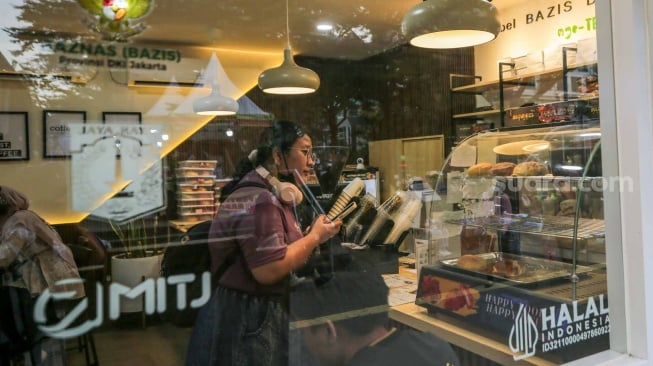 Pekerja yang juga penyandang disabilitas melayani pelanggan di Kopi Difabis, Terowongan Kendal, Jakarta, (9/6/2025). [Suara.com/Alfian Winanto]