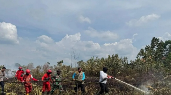 Bupati Kubu Raya Sujiwo bersama sejumlah pihak berjibaku memadamkan api di lahan yang terbakar di sekitar kawasan bandara (Prokopim Kubu Raya)