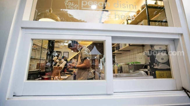 Pekerja yang juga penyandang disabilitas melayani pelanggan di Kopi Difabis, Terowongan Kendal, Jakarta, (9/6/2025). [Suara.com/Alfian Winanto]