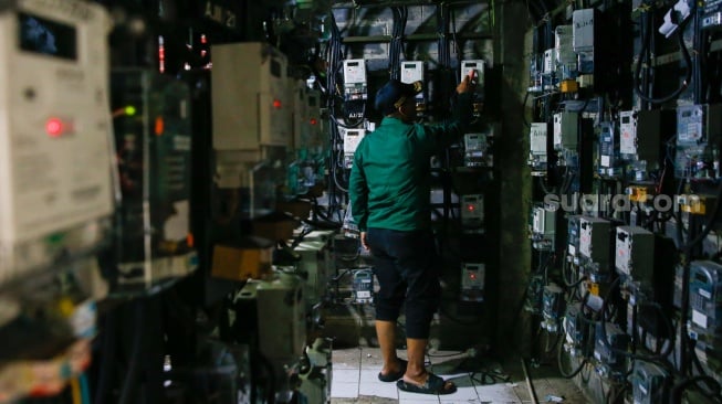Petugas mengecek meteran listrik di Rusun Bendungan Hilir, Jakarta, Selasa (10/6/2025). [Suara.com/Alfian Winanto]