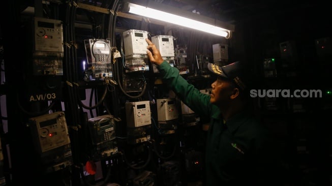 Petugas mengecek meteran listrik di Rusun Bendungan Hilir, Jakarta, Selasa (10/6/2025). [Suara.com/Alfian Winanto]