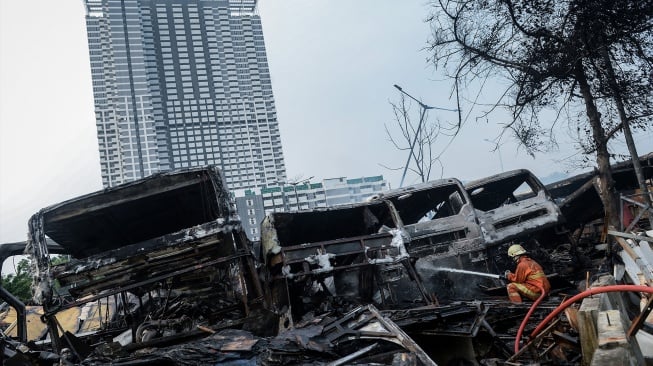 PPetugas pemadam kebakaran melakukan proses pendinginan usai memadamkan api yang membakar bus Transjakarta bekas di Terminal Rawa Buaya, Jakarta, Selasa (10/6/2025). [ANTARA FOTO/Putra M. Akbar/tom]