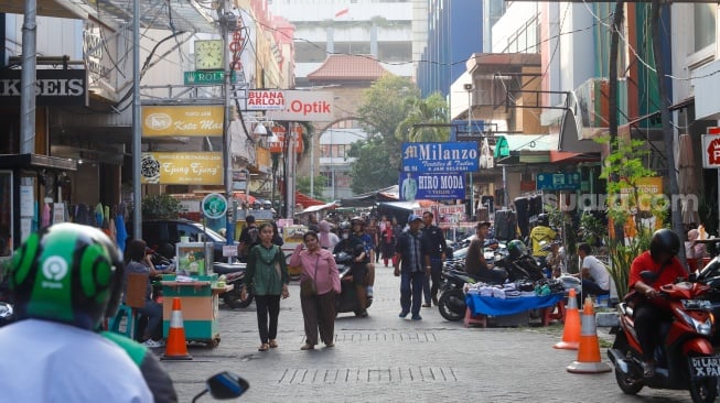 Warga berkunjung di kawasan Pasar Baru, Jakarta, Kamis (12/6/2025). [Suara.com/Alfian Winanto]
