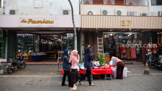 Warga berkunjung di kawasan Pasar Baru, Jakarta, Kamis (12/6/2025). [Suara.com/Alfian Winanto]
