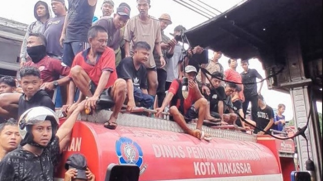 Warga menonton kebakaran di kawasan padat penduduk di Jalan Sabutung Baru, Kelurahan Pannampu, Kecamatan Tallo, Kota Makassar, Kamis, 12 Juni 2025 [SuaraSulsel.id/Istimewa]