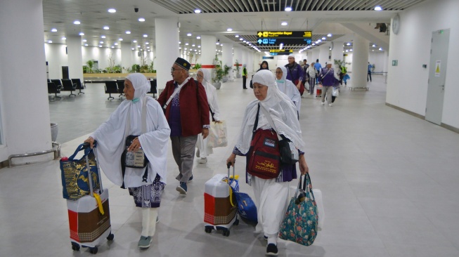 Jamaah haji debarkasi Padang bejalan di terminal kedatangan internasional setibanya di Bandara Internasional Minangkabau (BIM), Padang Pariaman, Sumatera Barat, Kamis (12/6/2025). [ANTARA FOTO/Iggoy el Fitra/nym]