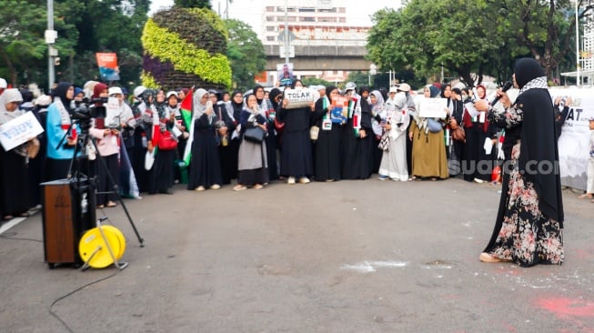 Sejumlah massa melakukan aksi solidaritas untuk Palestina di depan Kedutaan Besar Amerika untuk Indonesia, Jakarta, Jumat (13/6/2025). [Suara.com/Alfian Winanto]