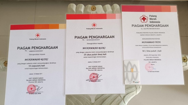 Rizki Al Hamid (kanan) saat menerima penghargaan dari PMI usai raih donor darah terbanyak dan termuda. (Foto dok. Rizki)