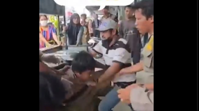Seorang pengemis buta diseret oleh petugas gabungan saat menggelar razia di Pematangsiantar. (tangkapan layar/X)