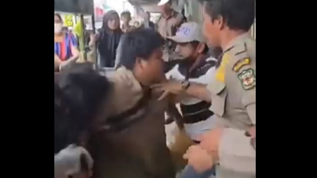 Seorang pengemis buta diseret oleh petugas gabungan saat menggelar razia di Pematangsiantar. (tangkapan layar/X)