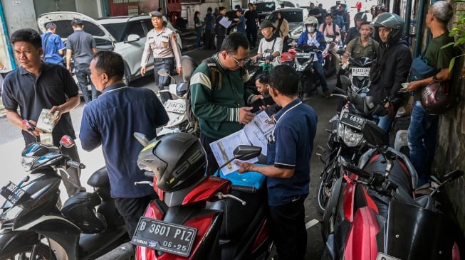 Petugas melakukan cek fisik kendaraan milik warga untuk pembayaran pajak kendaraan bermotor di Gedung Layanan Satu Atap Polda Metro Jaya, Jakarta, Senin (16/6/2025). [ANTARA FOTO/Sulthony Hasanuddin/tom]
