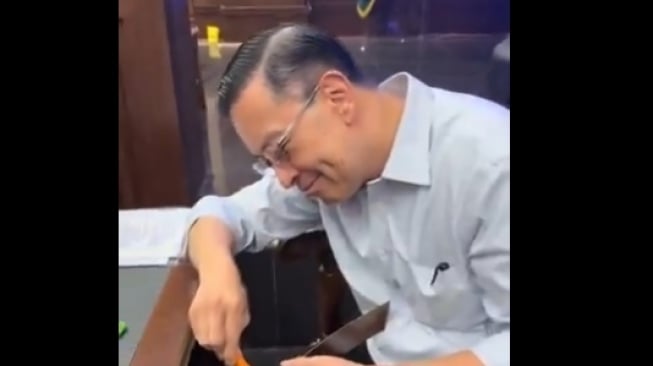 Beredar video di media sosial yang menampilkan mantan Menteri Perdagangan (Mendag) Thomas Trikasih Lembong alias Tom Lembong yang sedang memperbaiki kayu meja. Peristiwa itu terjadi ketika Tom Lembong sedang menjalani sidang sebagai terdakwa atas kasus dugaan korupsi impor gula. (Tangkapan layar/X)