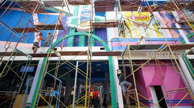 Pekerja menyelesaikan pembuatan gerai yang akan berpartisipasi dalam Jakarta Fair 2025 di JIExpo, Kemayoran, Jakarta, Rabu (18/6/2025). [Suara.com/Alfian Winanto]