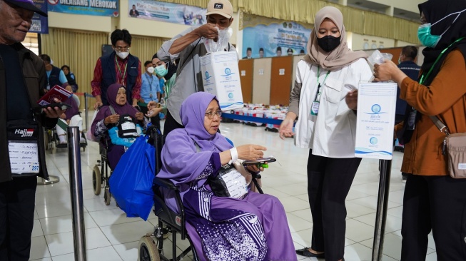Jamaah haji berjalan menuju bus tujuan Depok di UPT Asrama Haji Embarkasi Bekasi, Rabu (18/6/2025). Sebanyak 442 jamaah haji kloter 12 JKS tiba di Asrama Haji Embarkasi Bekasi setelah penerbangannya sempat terganggu karena pesawat Saudia Airlines SV 5276 rute JeddahâJakarta yang mereka tumpangi mendapat ancaman bom sehingga terpaksa mendarat di Bandara Kualanamu, Medan, Sumatra Utara. [Antara/I Gede Ferlian Septa Wahyusa]